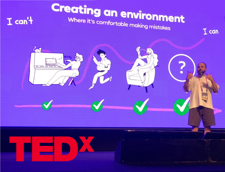 Maayan Malka on stage at TEDx, in front of a slide reading "Creating an environment where it's comfortable making mistakes"